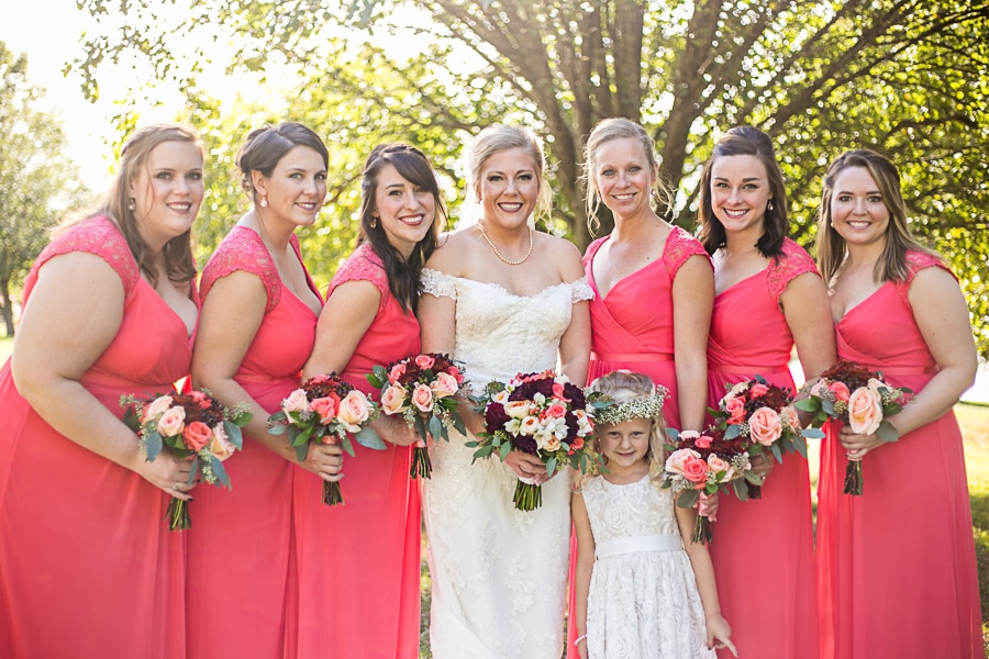 bride and her bridesmaids in coral dresses